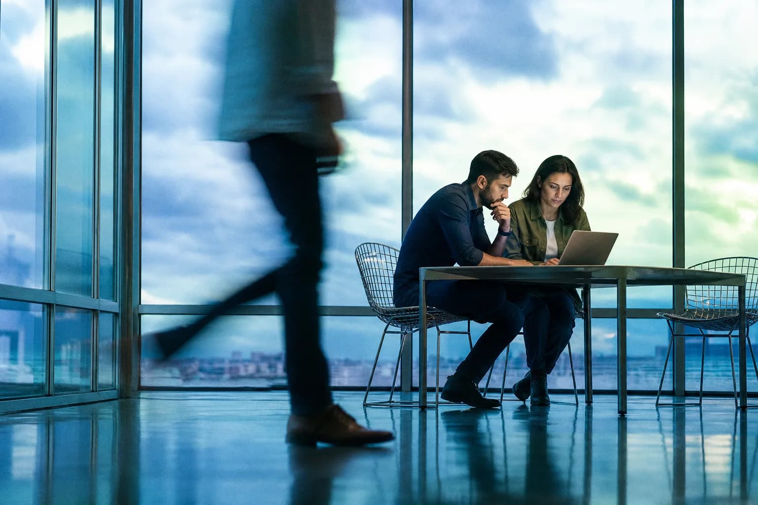 Digital team reviewing a website as movement crosses a blue-lit studio